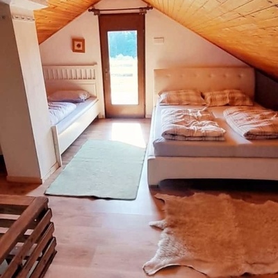 The larger bedroom is located in the attic and has access to the balcony.